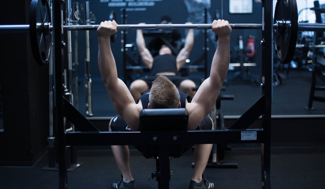 Man using a bench press in a bodybuilding gym